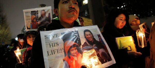 People holding placards take part in a vigil in front of Prime Minister Shinzo Abe's official residence in Tokyo, January 30, 2015 - Sputnik International