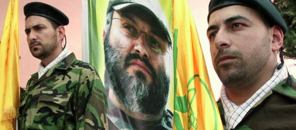 Hezbollah members stand guard in front of a picture of assassinated Hezbollah top commander Imad Imad Mughniyah - Sputnik International