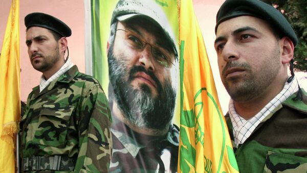 Hezbollah members stand guard in front of a picture of assassinated Hezbollah top commander Imad Mughniyeh - Sputnik International