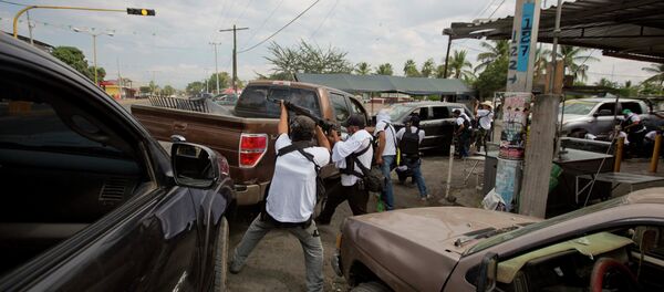 In this file photo, the Self-Defense Council of Michoacan (CAM) engage in a firefight as they try to flush out alleged members of the Knights Templar drug cartel from Nueva Italia, Mexico In this file photo, the Self-Defense Council of Michoacan (CAM) engage in a firefight as they try to flush out alleged members of the Knights Templar drug cartel from Nueva Italia, Mexico - Sputnik International