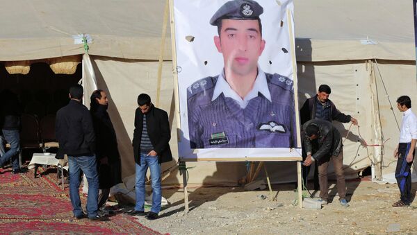 Relatives of Islamic State captive Jordanian pilot Muath al-Kasaesbeh place a poster of him in front of their new gathering headquarters in Amman January 30, 2015 - Sputnik International