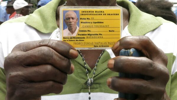 Former sugar cane worker Camilo Toussaint shows his identification card from the company he worked for during a sit-in outside Haiti's embassy in Santo Domingo - Sputnik International