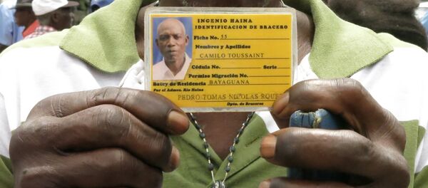 Former sugar cane worker Camilo Toussaint shows his identification card from the company he worked for during a sit-in outside Haiti's embassy in Santo Domingo Former sugar cane worker Camilo Toussaint shows his identification card from the company he worked for during a sit-in outside Haiti's embassy in Santo Domingo - Sputnik International