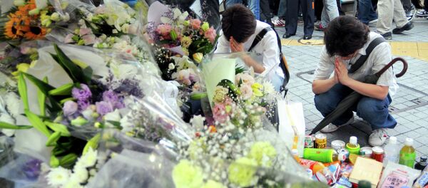 Two men offer prayer for victims of Sunday's knifing rampage in which seven people were stabbed to death at Tokyo's Akihabara shopping district - Sputnik International