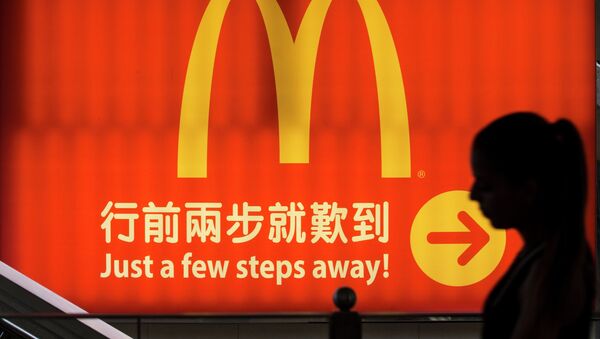 A woman walks past a logo of McDonald's in Hong Kong, in this file photo taken July 25, 2014 - Sputnik International