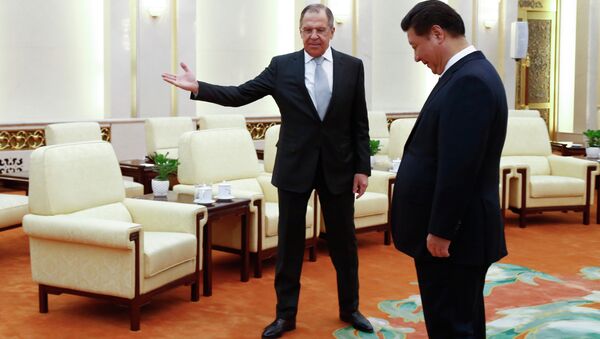 Russian Foreign Minister Sergey Lavrov, left, gestures to Chinese President Xi Jinping as Russian delegation members arrive for a meeting at the Great Hall of the People in Beijing Monday, Feb. 2, 2015 - Sputnik International