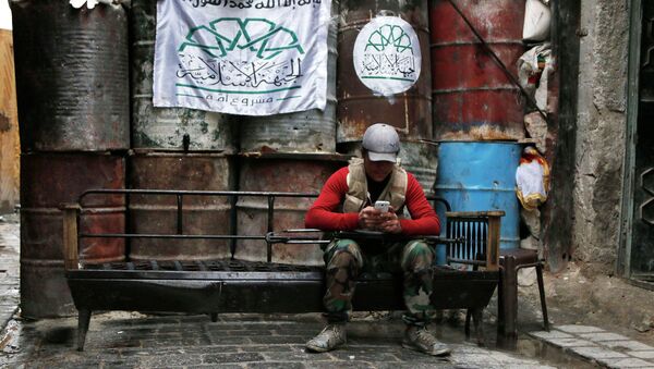 A rebel fighter uses his mobile phone beside barriers at a frontline in Old Aleppo - Sputnik International