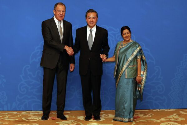 Russian Foreign Minister Sergei Lavrov (L), Chinese Foreign Minister Wang Yi (C) and Indian Foreign Minister Sushma Swaraj (R) shake hands as they for photographs before the thirteenth meeting of the Foreign Ministers of the China, Russia and India in Beijing on February 2, 2015 Russian Foreign Minister Sergei Lavrov (L), Chinese Foreign Minister Wang Yi (C) and Indian Foreign Minister Sushma Swaraj (R) shake hands as they for photographs before the thirteenth meeting of the Foreign Ministers of the China, Russia and India in Beijing on February 2, 2015 - Sputnik International
