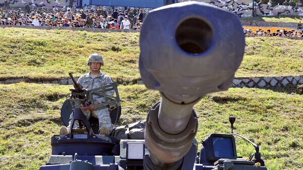 A US soldier sits on the top of M109A6 Paladin 155mm Howitzer during a joint military exercise on the Seungjin Fire Training Field in Pocheon, 30 kms south of the border with North Korea . File photo - Sputnik International