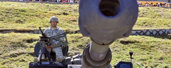A US soldier sits on the top of M109A6 Paladin 155mm Howitzer - Sputnik International