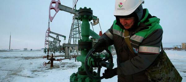 A worker checks the valve of an oil pipe at an oil field owned by Bashneft company near the village of Nikolo-Berezovka, northwest from Ufa, Bashkortostan, January 28, 2015 - Sputnik International