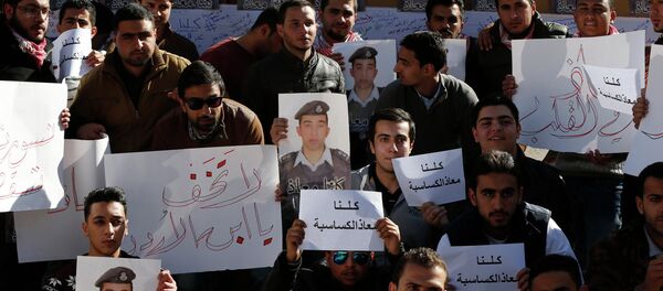 Students hold pictures of Islamic State captive Jordanian pilot Muath al-Kasaesbeh - Sputnik International