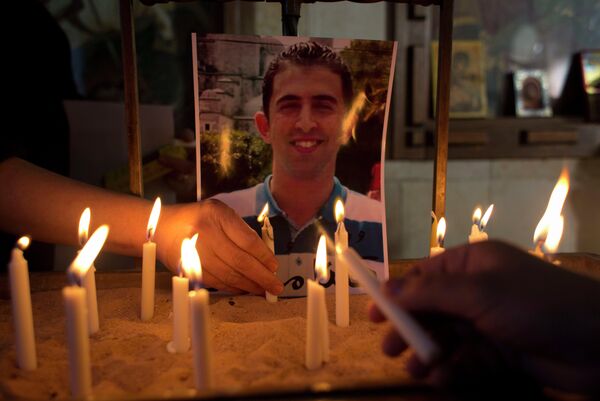Two Jordanian women light candles next to a picture of Jordanian pilot Lt. Muath al-Kaseasbeh, who was murdered by Islamic State militants. Two Jordanian women light candles next to a picture of Jordanian pilot Lt. Muath al-Kaseasbeh, who was murdered by Islamic State militants. - Sputnik International