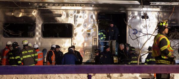 Emergency workers stand in and around a burnt Metropolitan Transportation Authority (MTA) Metro North Railroad commuter train near the town of Valhalla, New York, February 3, 2015. - Sputnik International