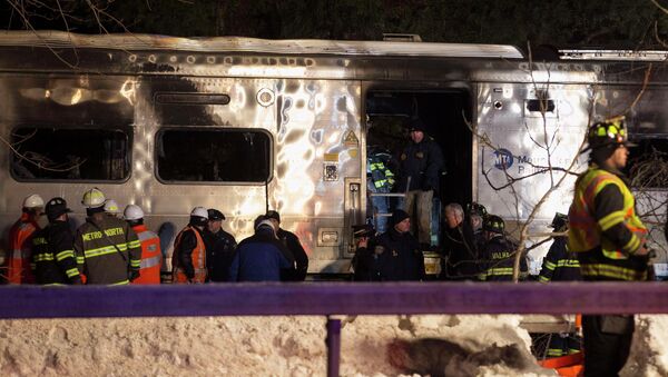Emergency workers stand in and around a burnt Metropolitan Transportation Authority (MTA) Metro North Railroad commuter train near the town of Valhalla, New York, February 3, 2015. - Sputnik International