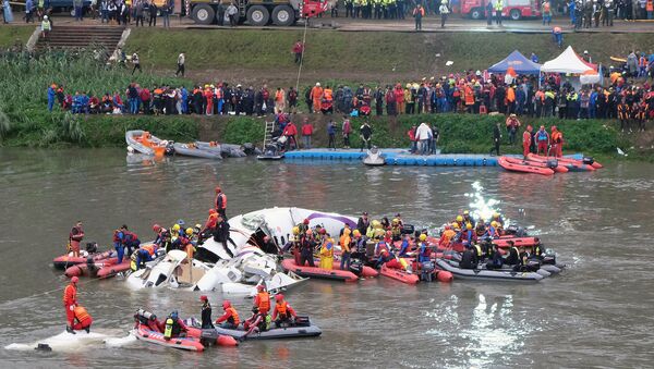 Rescue personnel search for passengers from the wreckage of a TransAsia ATR 72-600 turboprop plane that crash-landed into the Keelung river outside Taiwan's capital Taipei in New Taipei City on February 4, 2015. - Sputnik International