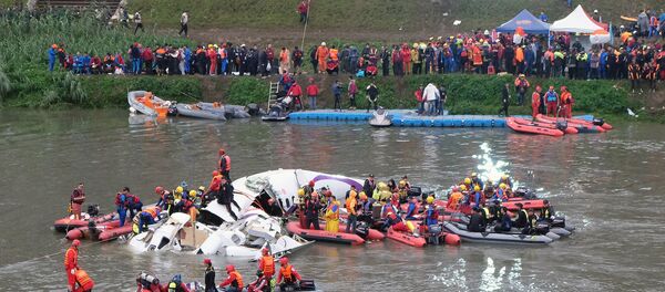 Rescue personnel search for passengers from the wreckage of a TransAsia ATR 72-600 turboprop plane that crash-landed into the Keelung river outside Taiwan's capital Taipei in New Taipei City on February 4, 2015. Rescue personnel search for passengers from the wreckage of a TransAsia ATR 72-600 turboprop plane that crash-landed into the Keelung river outside Taiwan's capital Taipei in New Taipei City on February 4, 2015. - Sputnik International