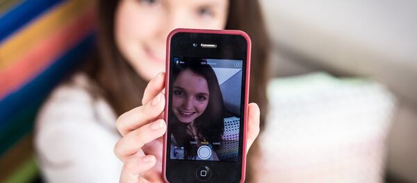 A teenage girl taking a picture of herself on her smartphone - Sputnik International