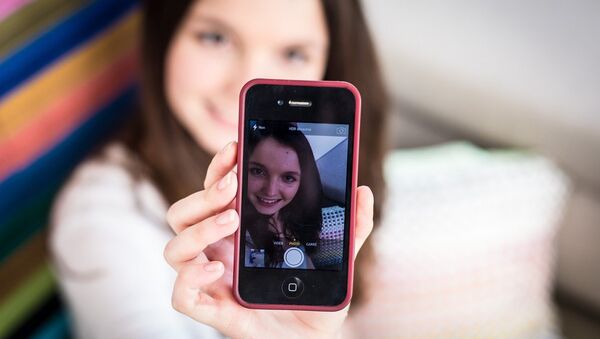 A teenage girl taking a picture of herself on her smartphone - Sputnik International