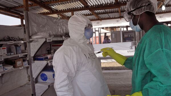 A health care worker assists a collegue inside a USAID, funded Ebola clinic in Monrovia, Liberia, Friday, Jan. 30, 2015. The World Health Organization says officials are now focused on ending the biggest-ever Ebola outbreak rather than just slowing the virus’ spread. In an update published Thursday, Jan. 29, 2015, the U.N. health agency said the three most affected countries _ Guinea, Sierra Leone and Liberia _ reported fewer than 100 cases in the past week, for the first time since June, 2014. - Sputnik International