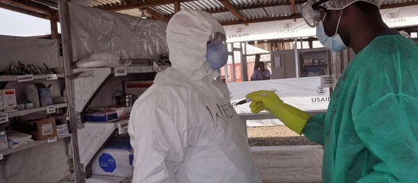 A health care worker assists a collegue inside a USAID, funded Ebola clinic in Monrovia, Liberia, Friday, Jan. 30, 2015. The World Health Organization says officials are now focused on ending the biggest-ever Ebola outbreak rather than just slowing the virus’ spread. In an update published Thursday, Jan. 29, 2015, the U.N. health agency said the three most affected countries _ Guinea, Sierra Leone and Liberia _ reported fewer than 100 cases in the past week, for the first time since June, 2014. A health care worker assists a collegue inside a USAID, funded Ebola clinic in Monrovia, Liberia, Friday, Jan. 30, 2015. The World Health Organization says officials are now focused on ending the biggest-ever Ebola outbreak rather than just slowing the virus’ spread. In an update published Thursday, Jan. 29, 2015, the U.N. health agency said the three most affected countries _ Guinea, Sierra Leone and Liberia _ reported fewer than 100 cases in the past week, for the first time since June, 2014. - Sputnik International