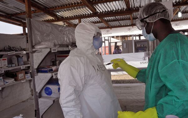 A health care worker assists a collegue inside a USAID, funded Ebola clinic in Monrovia, Liberia, Friday, Jan. 30, 2015. The World Health Organization says officials are now focused on ending the biggest-ever Ebola outbreak rather than just slowing the virus’ spread. In an update published Thursday, Jan. 29, 2015, the U.N. health agency said the three most affected countries _ Guinea, Sierra Leone and Liberia _ reported fewer than 100 cases in the past week, for the first time since June, 2014. - Sputnik International