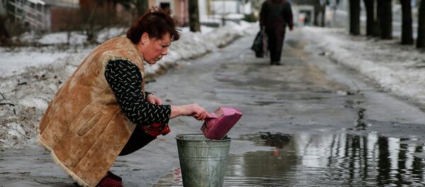 A woman gathers water in Donetsk - Sputnik International