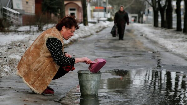 A woman gathers water in Donetsk - Sputnik International