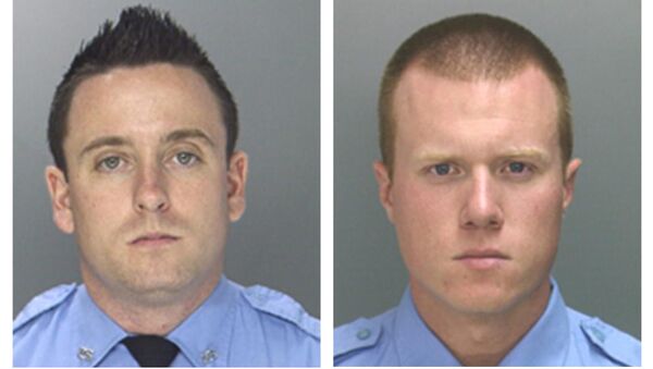 Officers Sean McKnight, left, and Kevin Robinson are shown. The two officers face brutality charges after prosecutors say they knocked a man off a scooter and beat him so severely another officer thought the bloodied man had been shot. They were charged Thursday, Feb. 5, 2015 with assault, criminal conspiracy and reckless endangerment. They're also charged with lying about the May 2013 incident. - Sputnik International