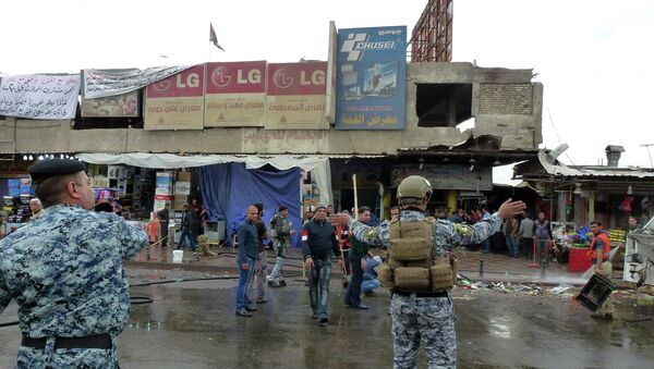 Iraqi police clear pedestrians of a street after a suicide bomber detonated explosives inside a restaurant in Baghdad al-Jadida, east of the capital, on February 7, 2015 - Sputnik International