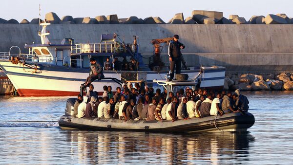 Sub-Saharan African migrants are rescued by the Libyan coastguard after their inflatable boat started to sink off the coastal town of Guarabouli. File photo - Sputnik International