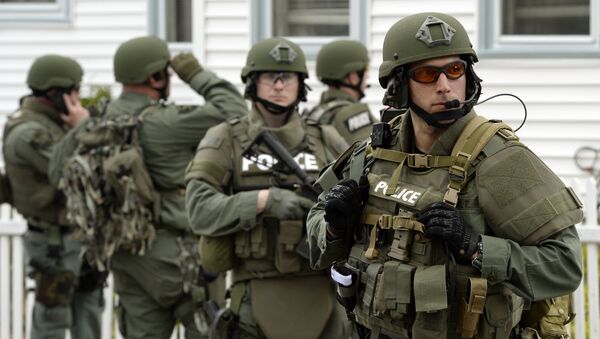 The six stand accused of sending material support, including military equipment, from the US to the Islamic State in Syria.  Above: A police SWAT team search houses for the second of two suspects wanted in the Boston Marathon bombings. - Sputnik International