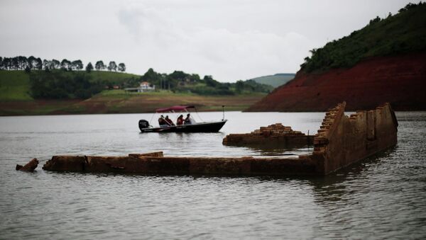Tourists drive a boat past the walls of the old school of the re-emerging old city of Igarata in the Jaguari reservoir, Sao Paulo State, February 4, 2015 - Sputnik International