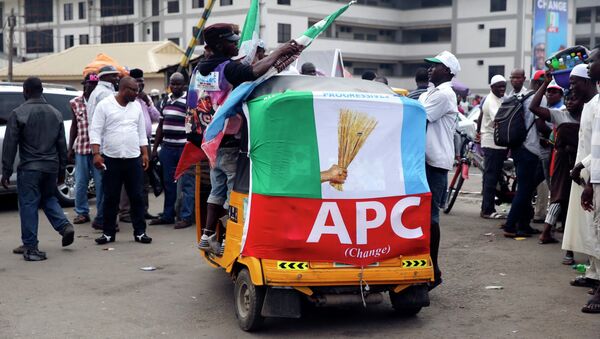 Men ride on a transport wrapped with a banner campaigning for All Progressives Congress (APC) outside a campaign rally in Yaba district in Lagos February 5, 2015 - Sputnik International