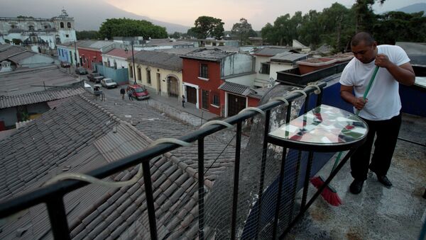 A waiter sweeps the ash covered terrace of a restaurant, from the eruption of the Fuego Volcano at Antigua Guatemala, Saturday, Feb. 7, 2015 - Sputnik International