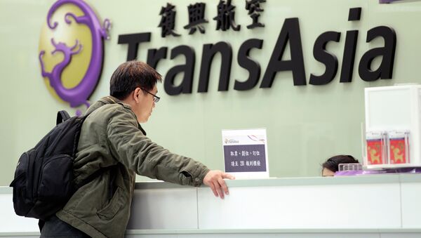 A passenger waits at the ticket counter of TransAsia Airways at the Songshan Airport in Taipei, Taiwan, Saturday, Feb. 7, 2015 - Sputnik International