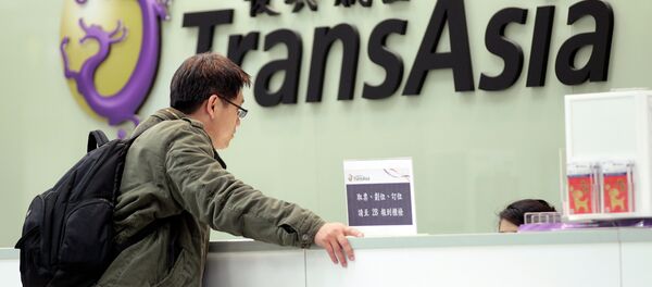 A passenger waits at the ticket counter of TransAsia Airways at the Songshan Airport in Taipei, Taiwan, Saturday, Feb. 7, 2015 A passenger waits at the ticket counter of TransAsia Airways at the Songshan Airport in Taipei, Taiwan, Saturday, Feb. 7, 2015 - Sputnik International