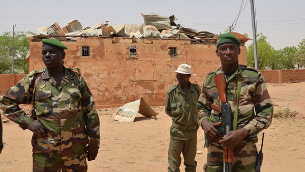 Nigerien soldiers stand near a damaged building in an army base in Agadez, northern Niger on May 26, 2013 - Sputnik International