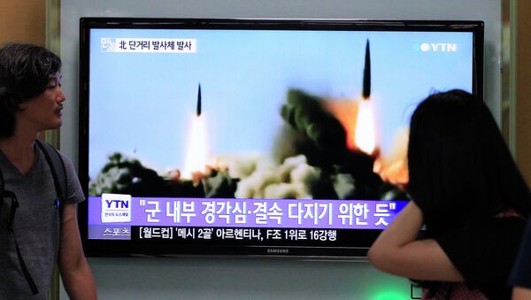 People watch a TV news program showing the missile launch conducted by North Korea, at Seoul Railway Station in Seoul, South Korea, Thursday, June 26, 2014 - Sputnik International