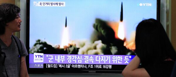 People watch a TV news program showing the missile launch conducted by North Korea, at Seoul Railway Station in Seoul, South Korea, Thursday, June 26, 2014 - Sputnik International