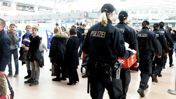 Police officers pass a row of waiting passengers during a strike of security employees at the airport Fuhlsbuettel in Hamburg, February 9, 2015 - Sputnik International