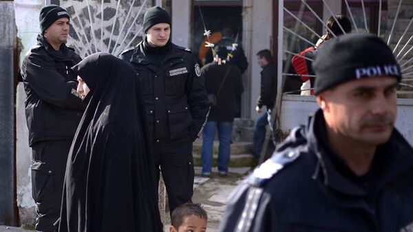 Policemen stand guard, during a search operation of a house in the Roma suburb in the city of Pazardjik, South West Bulgaria, on November 25, 2014 - Sputnik International