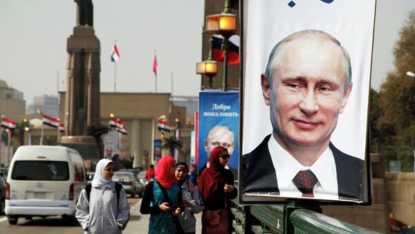 Girls walk past a banner with a picture of Russian President Vladimir Putin along a bridge, in central Cairo February 9, 2015 - Sputnik International