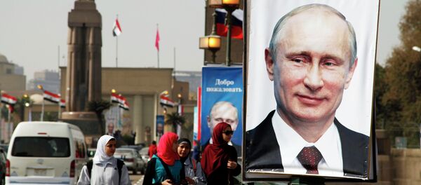 Girls walk past a banner with a picture of Russian President Vladimir Putin along a bridge, in central Cairo February 9, 2015 Girls walk past a banner with a picture of Russian President Vladimir Putin along a bridge, in central Cairo February 9, 2015 - Sputnik International