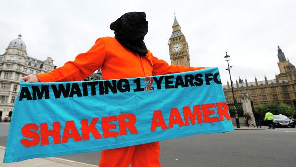 A protester holds up a banner during a protest against the Guantanamo Bay detention camp, in Parliament Square in London - Sputnik International