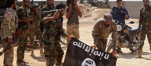 Iraqi security forces hold a captured ISIL flag in October, 2014. Iraqi security forces hold a captured ISIL flag in October, 2014. - Sputnik International