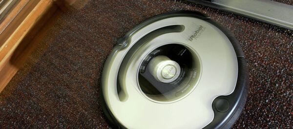 The Roomba vacuum cleaner by iRobot Corp. moves to clean an office carpet in Boston on Tuesday, Aug. 21, 2007. Nearly five years after rolling onto the market, the Roomba vacuum cleaner has undergone a ground-up redesign that has endowed the otherwise-brainy robot with the smarts to overcome rug tassels and electrical cords. - Sputnik International
