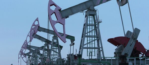 A worker walks past pump jacks on an oil field owned by Bashneft company near the village of Nikolo-Berezovka, northwest from Ufa, Bashkortostan, January 28, 2015 - Sputnik International