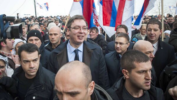 Kosovo Serbs gather holding up their national flag as they welcome Serbian Prime Minister Aleksandar Vucic, surrounded by body guards, to the village of Pasjane, during his visit to Kosovo. - Sputnik International