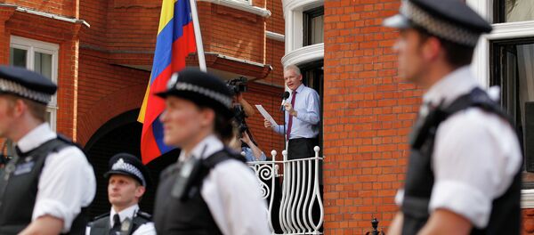 Surrounded by British police WikiLeaks founder Julian Assange, centre, makes a statement to the media and supporters from a window of Ecuadorian Embassy in central London. Surrounded by British police WikiLeaks founder Julian Assange, centre, makes a statement to the media and supporters from a window of Ecuadorian Embassy in central London. - Sputnik International